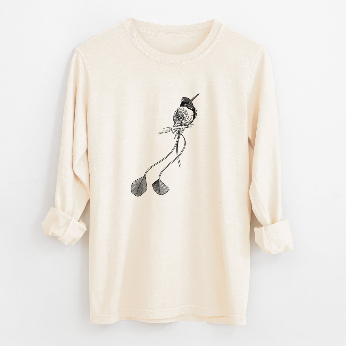 Ivory Comfort Colors long sleeve shirt laid flat with the cuffs rolled, printed with a black ink illustration of a marvelous spatuletail hummingbird perched, with its two long racket-tipped tail feathers.