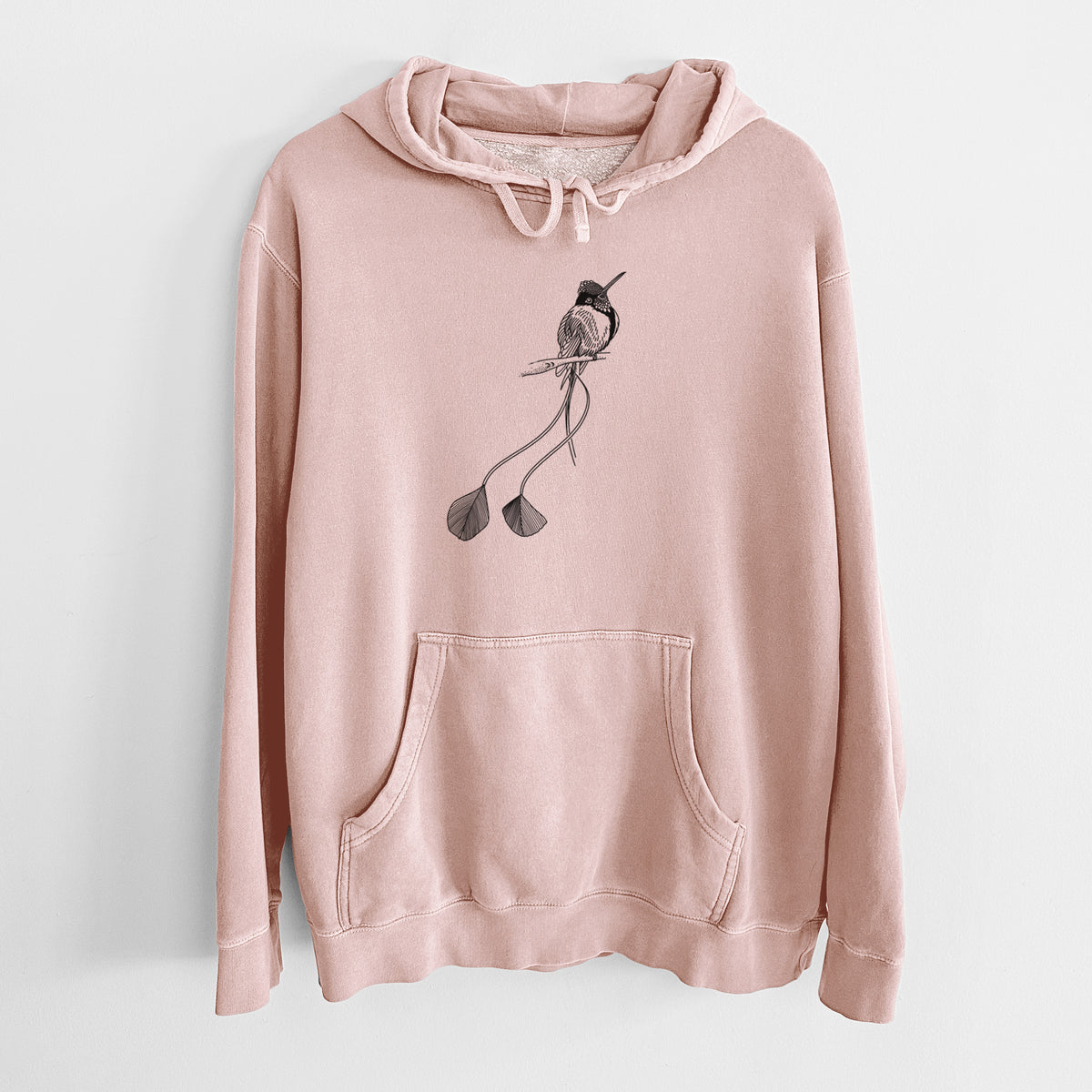 Dusty pink pigment dyed hoodie laid flat, printed with a black ink illustration of a marvelous spatuletail hummingbird perched, with its two long racket-tipped tail feathers.