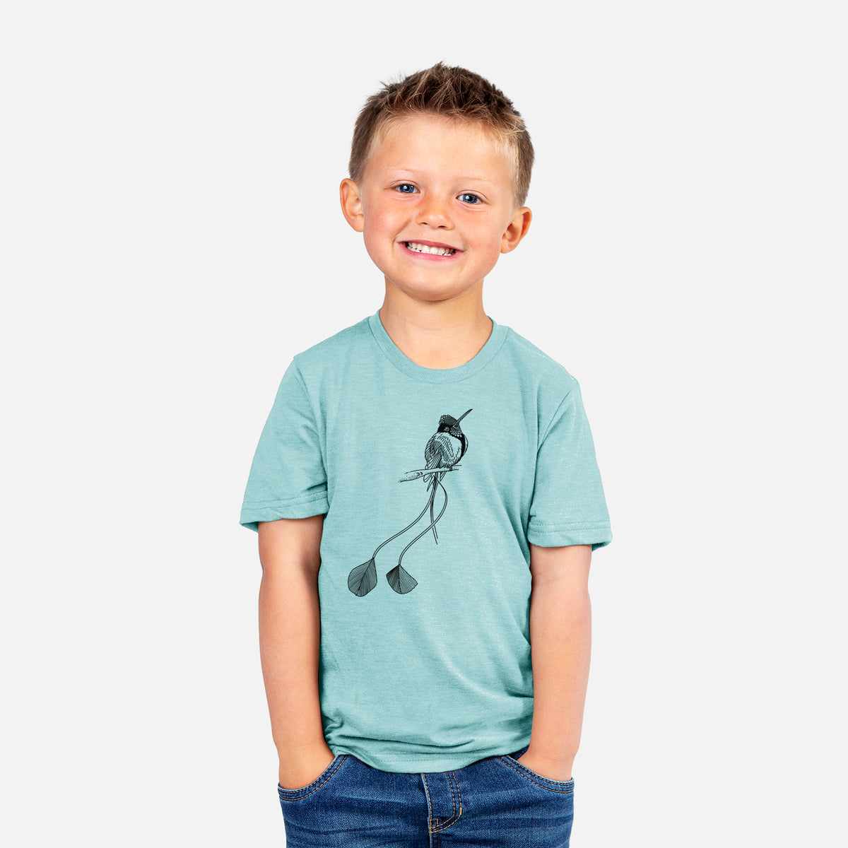 Smiling boy wearing a youth t-shirt printed with a black ink illustration of a marvelous spatuletail hummingbird perched, with its two long racket-tipped tail feathers.