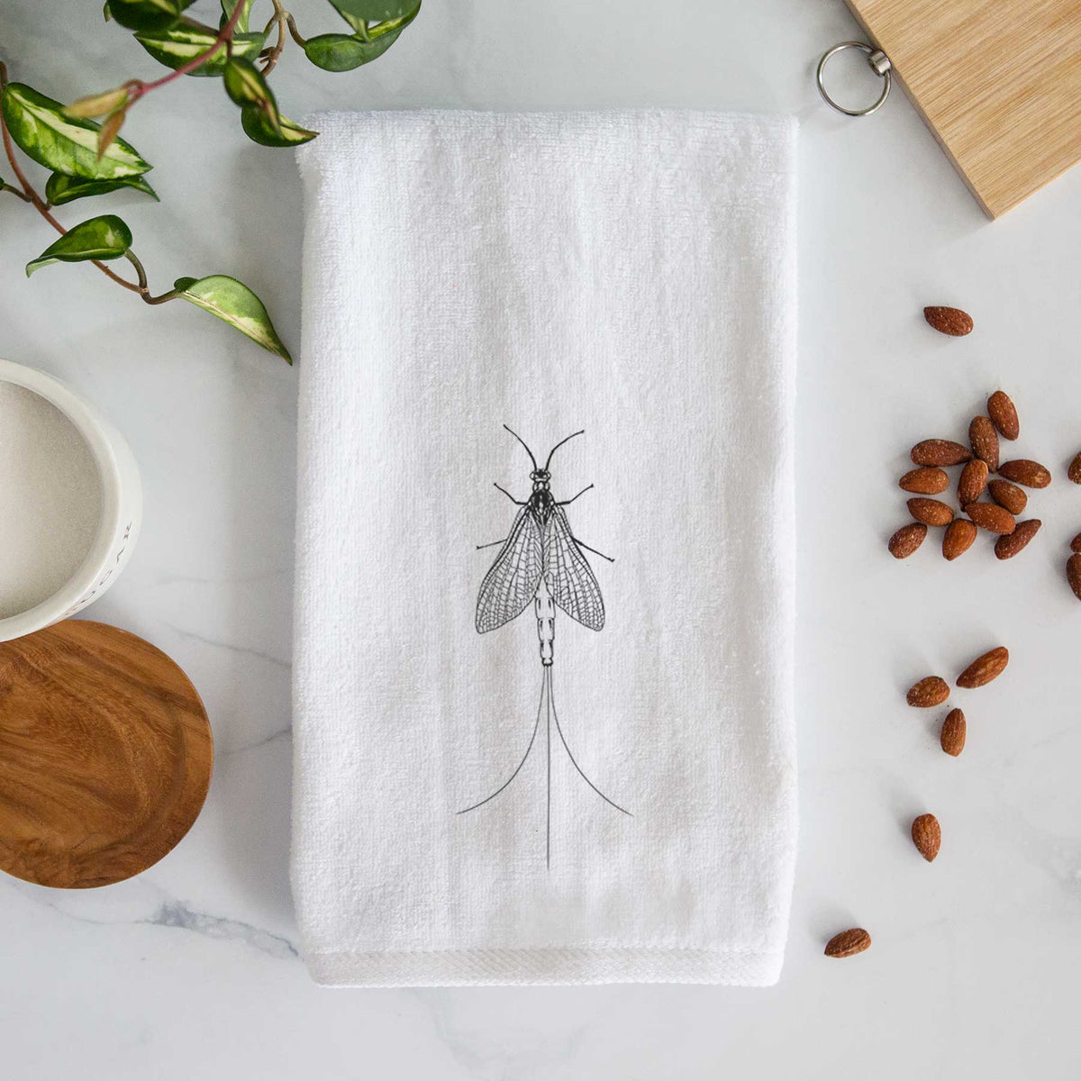 White hand towel printed with a detailed black ink illustration of a mayfly with its wings raised and long tail filaments.