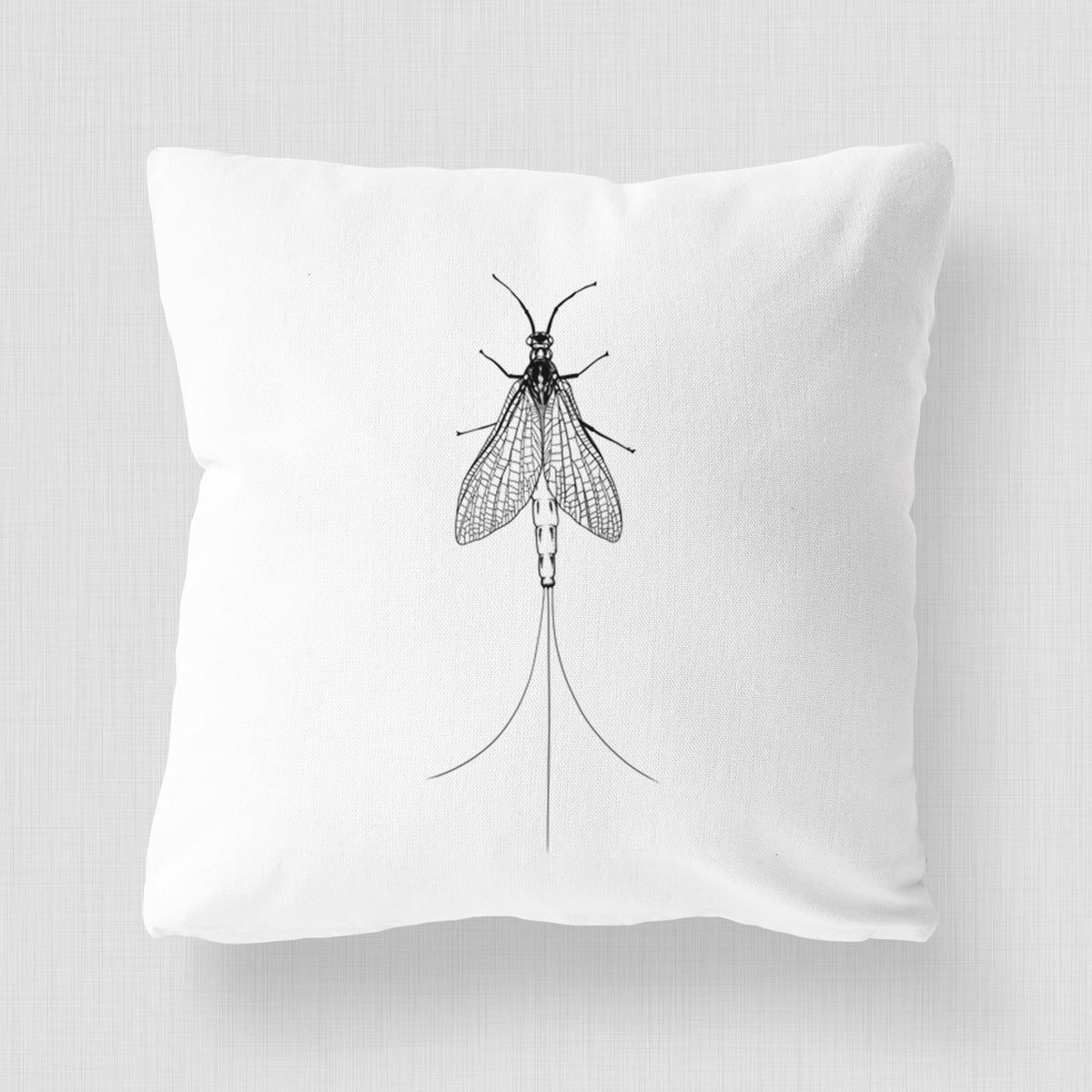 White pillow cover printed with a detailed black ink illustration of a mayfly with its wings raised and long tail filaments.