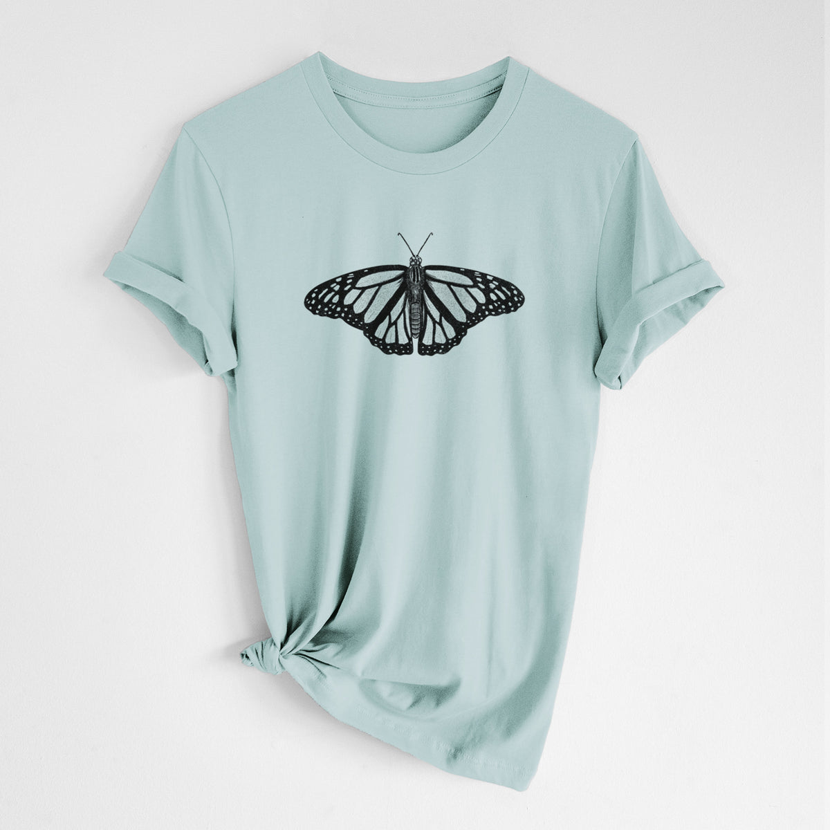 Dusty blue lightweight cotton t-shirt laid flat with the sleeves rolled, printed with a detailed black ink illustration of a monarch butterfly with its wings spread.