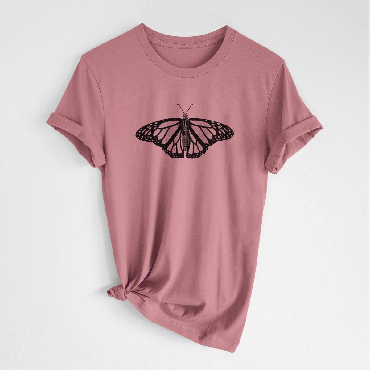 Mauve pink lightweight cotton t-shirt laid flat with the sleeves rolled, printed with a detailed black ink illustration of a monarch butterfly with its wings spread.