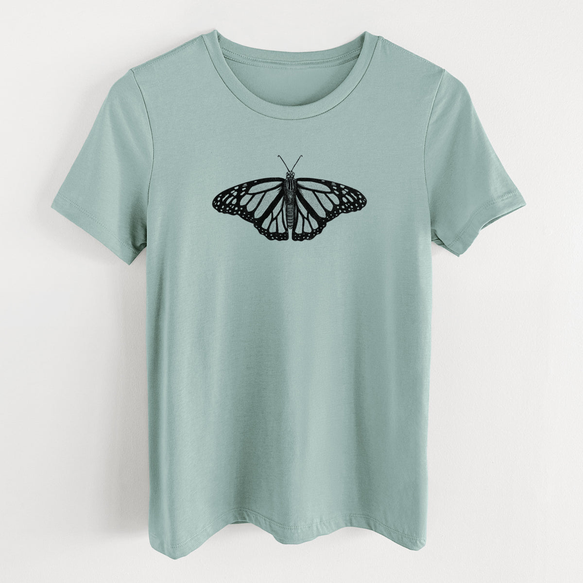 Dusty blue women's relaxed fit cotton t-shirt laid flat, printed with a detailed black ink illustration of a monarch butterfly with its wings spread.