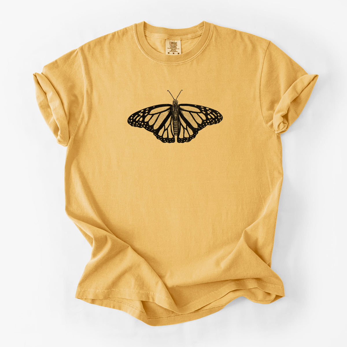 Golden wheat yellow Comfort Colors t-shirt laid flat, printed with a detailed black ink illustration of a monarch butterfly with its wings spread.