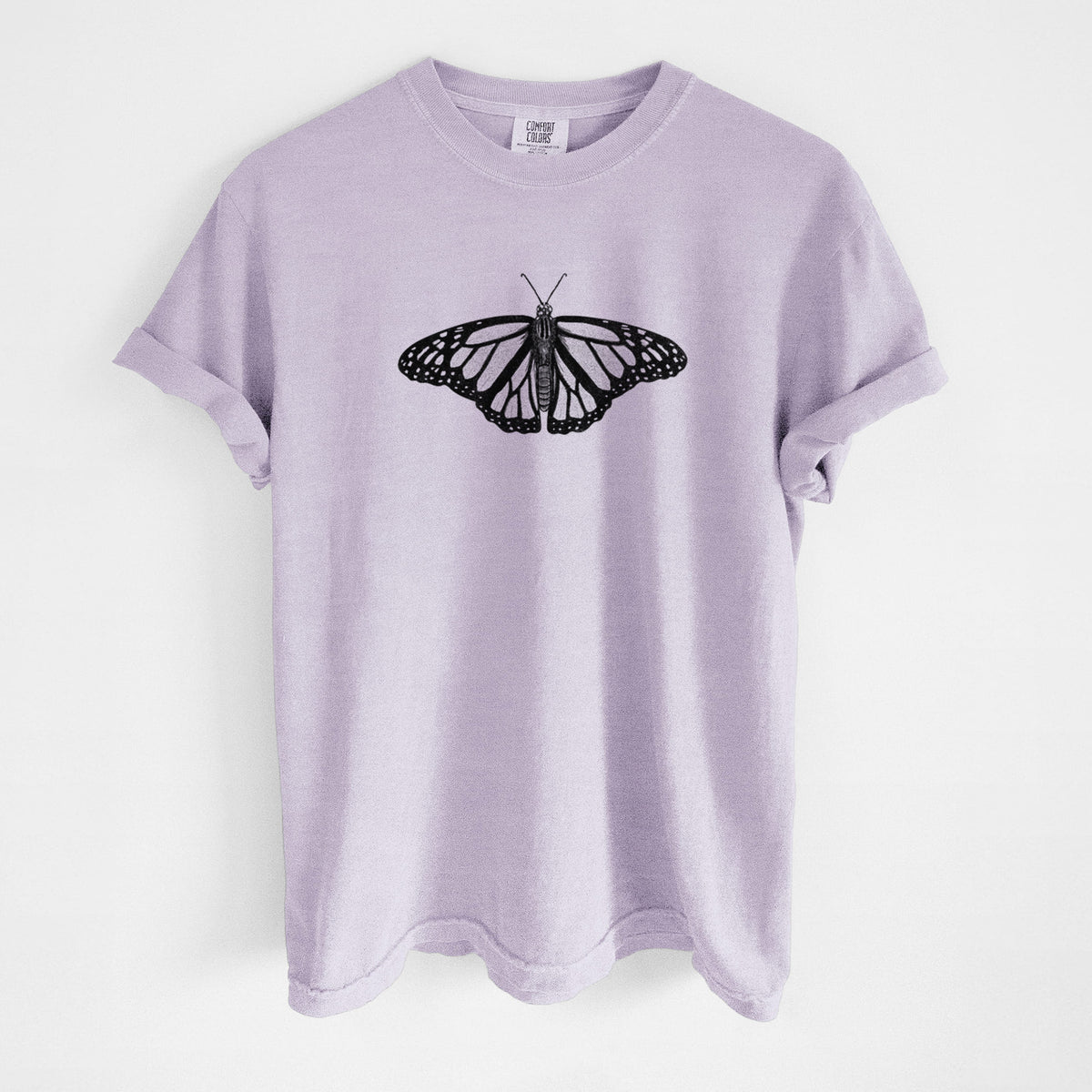 Orchid purple Comfort Colors t-shirt laid flat, printed with a detailed black ink illustration of a monarch butterfly with its wings spread.
