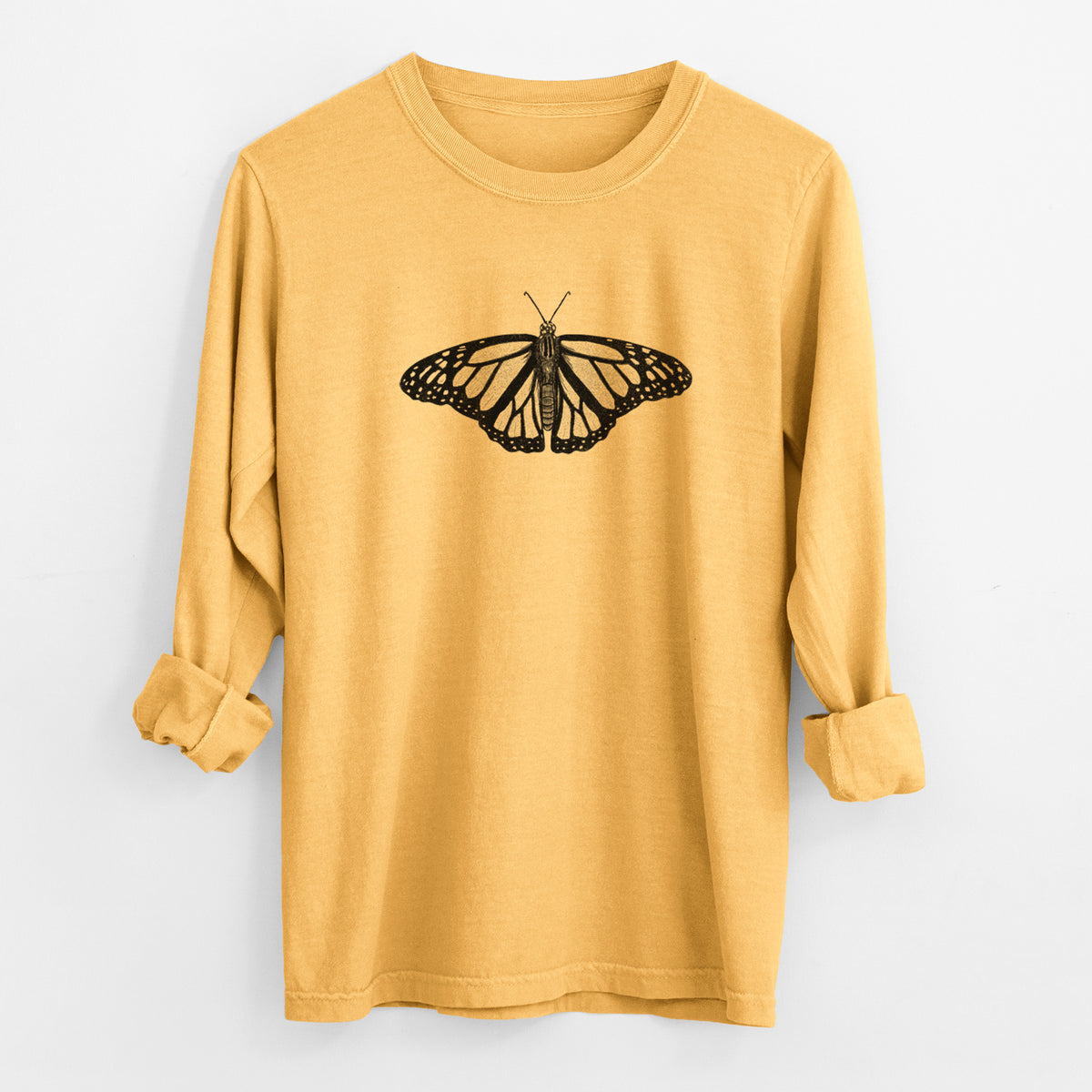 Golden wheat yellow Comfort Colors long sleeve shirt laid flat with the cuffs rolled, printed with a detailed black ink illustration of a monarch butterfly with its wings spread.