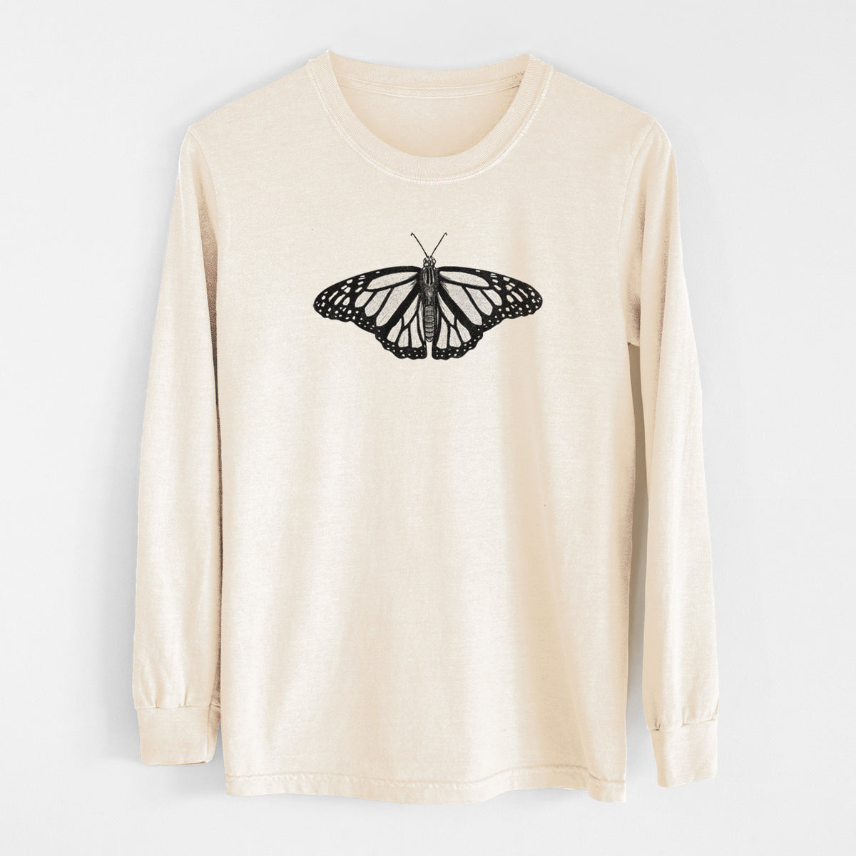Ivory Comfort Colors long sleeve shirt laid flat, printed with a detailed black ink illustration of a monarch butterfly with its wings spread.