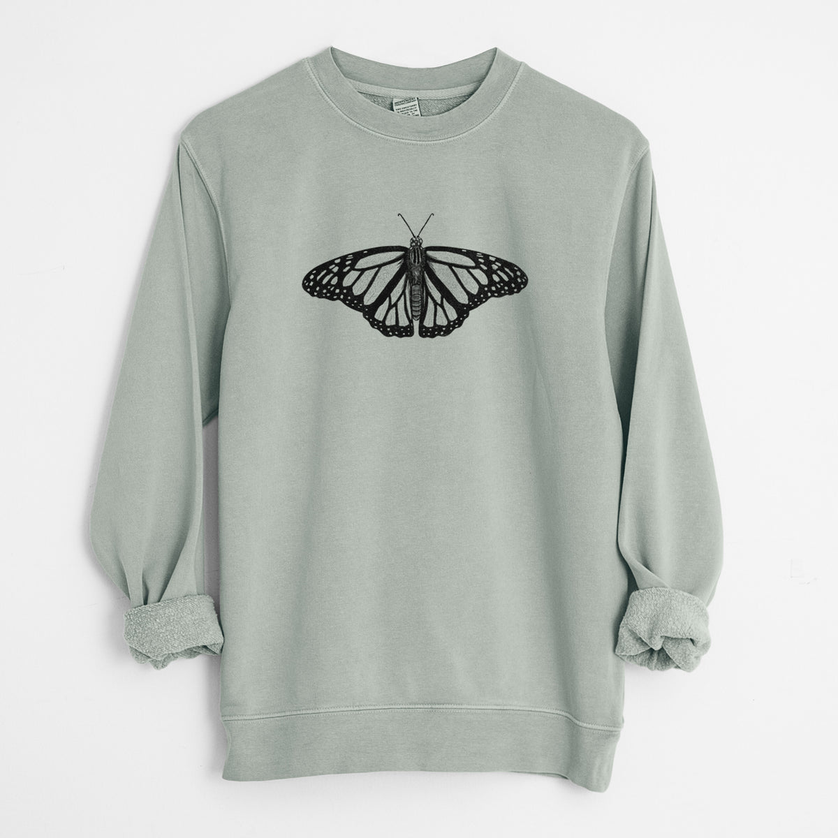 Sage green pigment dyed crewneck sweatshirt laid flat with the sleeves rolled, printed with a detailed black ink illustration of a monarch butterfly with its wings spread.