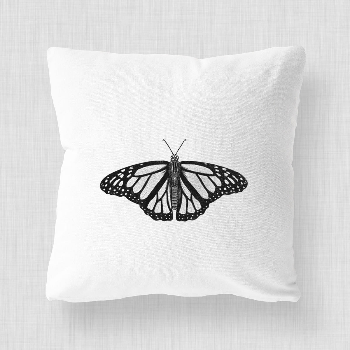 White pillow cover printed with a detailed black ink illustration of a monarch butterfly with its wings spread.