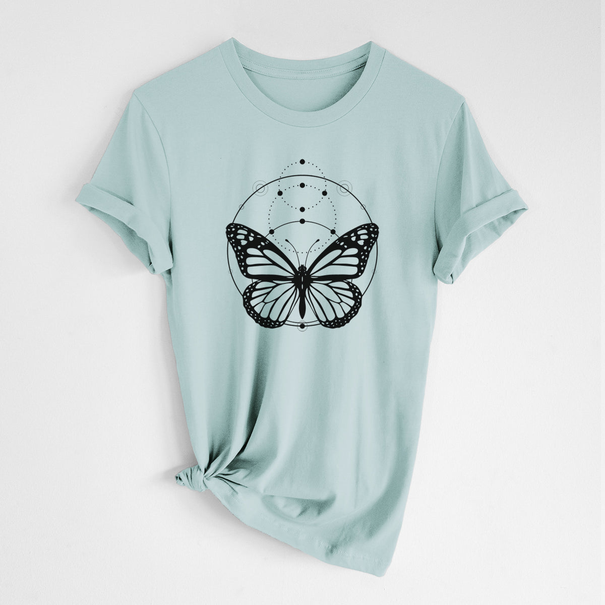 Dusty blue lightweight cotton t-shirt laid flat with the sleeves rolled, printed with a black ink monarch butterfly inside a circle, beneath a line of moon phases.