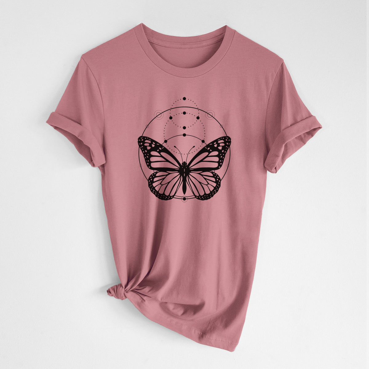 Mauve pink lightweight cotton t-shirt laid flat with the sleeves rolled, printed with a black ink monarch butterfly inside a circle, beneath a line of moon phases.