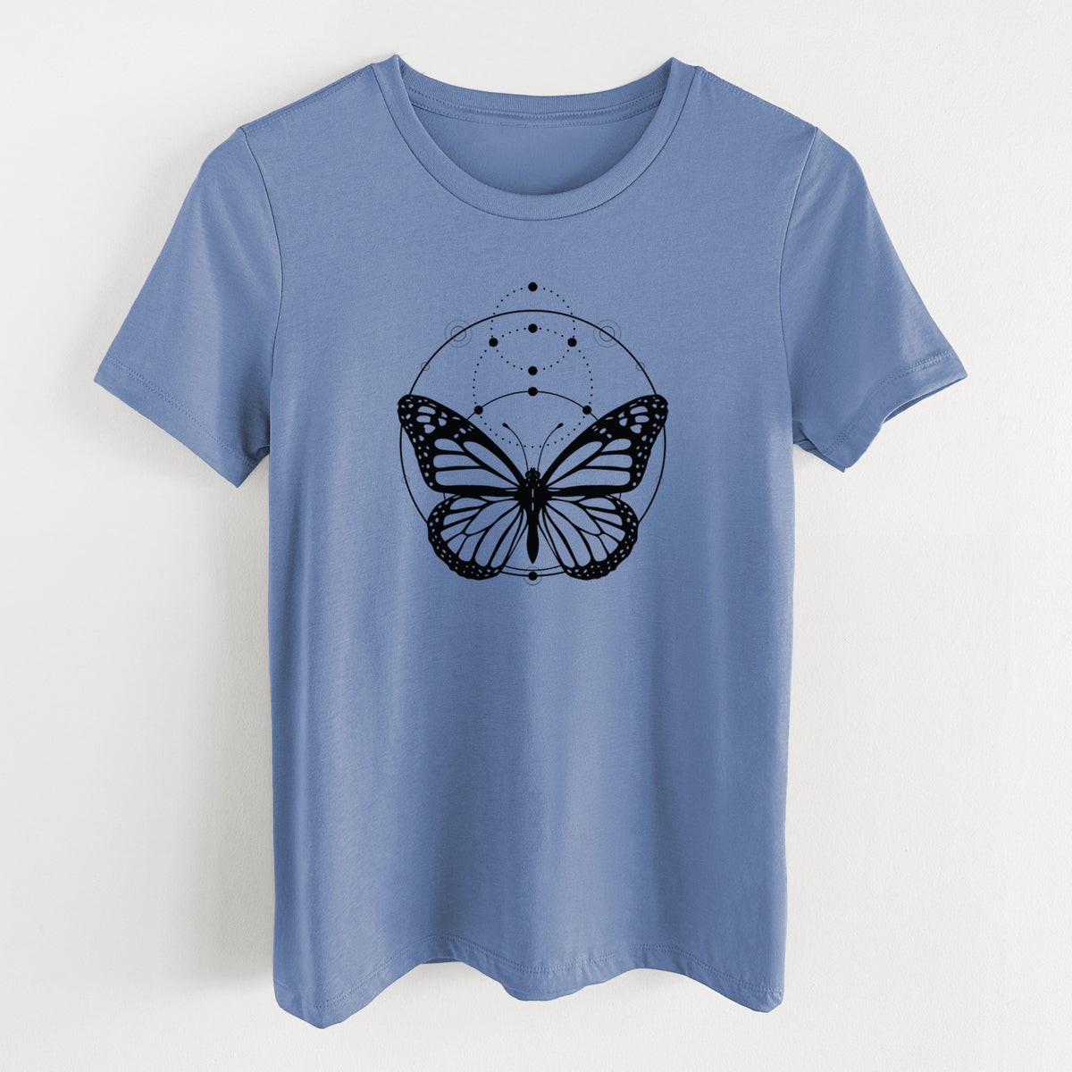 Blue bell women's relaxed fit cotton t-shirt laid flat, printed with a black ink monarch butterfly inside a circle, beneath a line of moon phases.