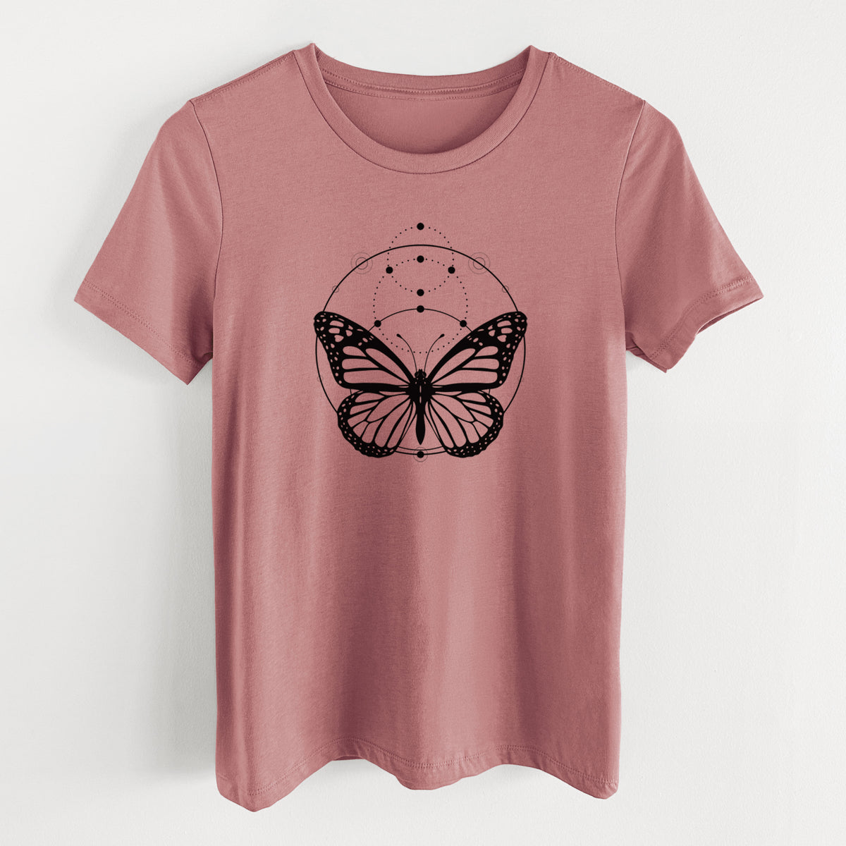 Mauve pink women's relaxed fit cotton t-shirt laid flat, printed with a black ink monarch butterfly inside a circle, beneath a line of moon phases.