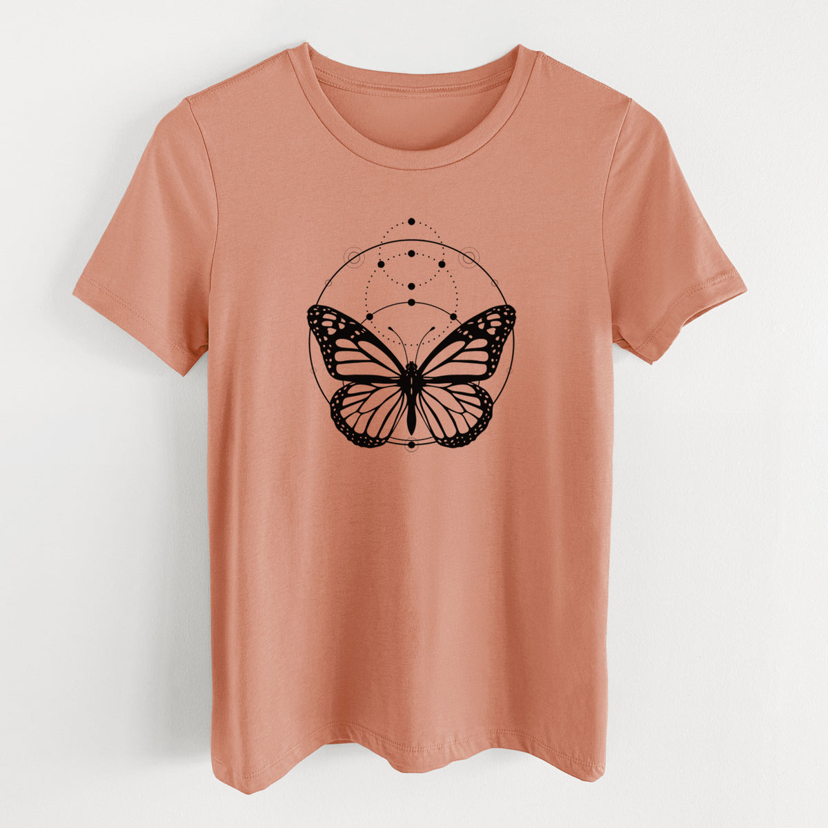 Terracotta orange women's relaxed fit cotton t-shirt laid flat, printed with a black ink monarch butterfly inside a circle, beneath a line of moon phases.