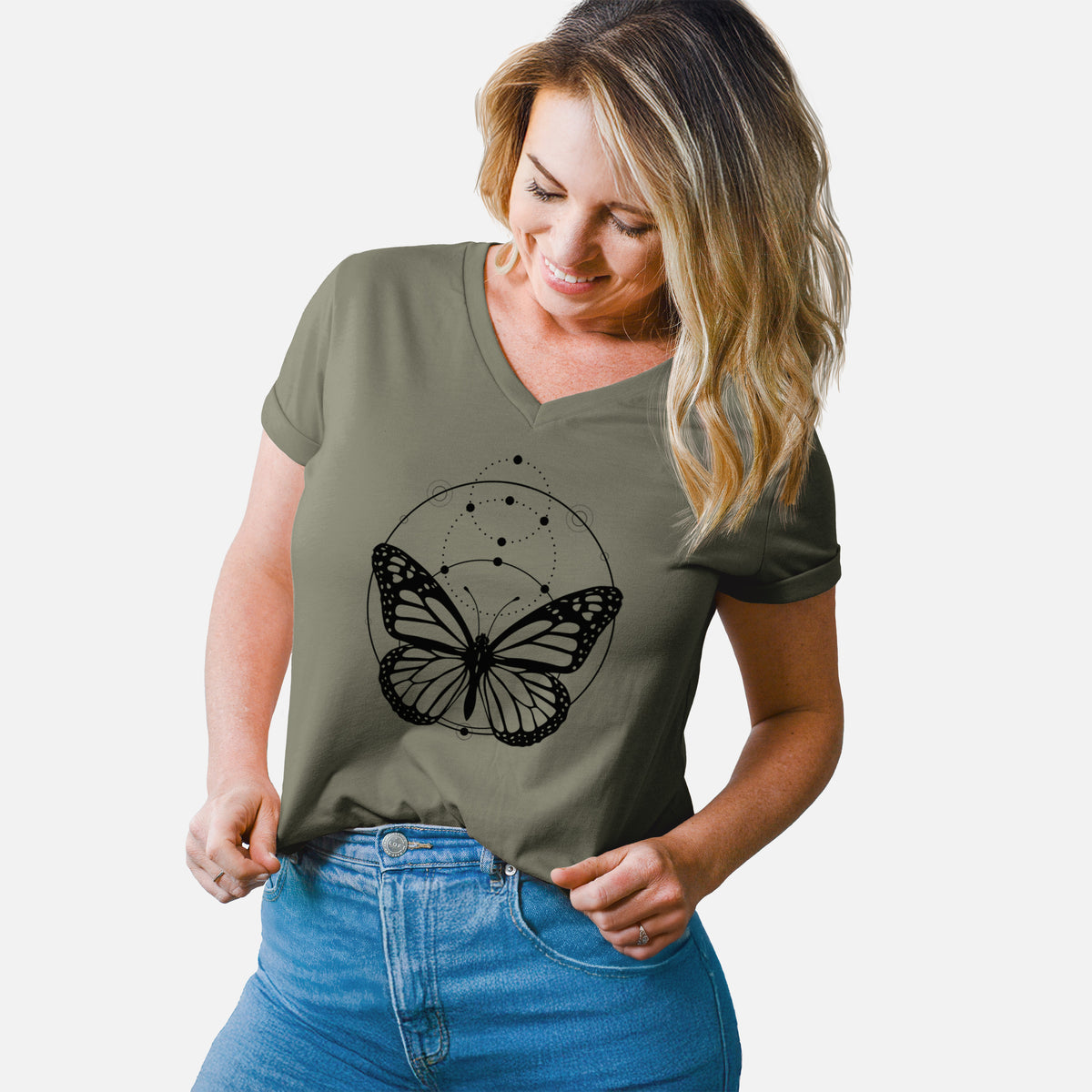 Woman wearing a military green women's relaxed fit cotton V-neck t-shirt printed with a black ink monarch butterfly inside a circle, beneath a line of moon phases.