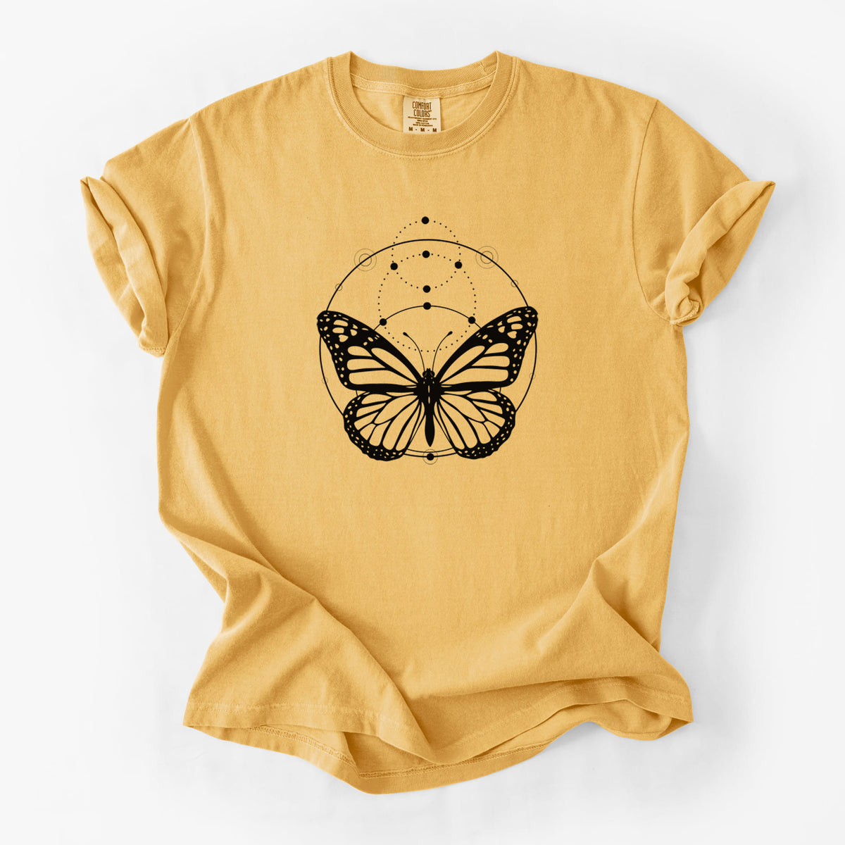 Golden wheat yellow Comfort Colors t-shirt laid flat, printed with a black ink monarch butterfly inside a circle, beneath a line of moon phases.
