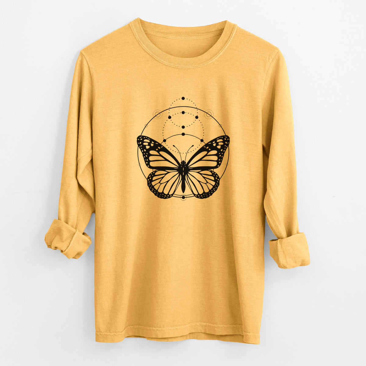 Golden wheat yellow Comfort Colors long sleeve shirt laid flat with the cuffs rolled, printed with a black ink monarch butterfly inside a circle, beneath a line of moon phases.