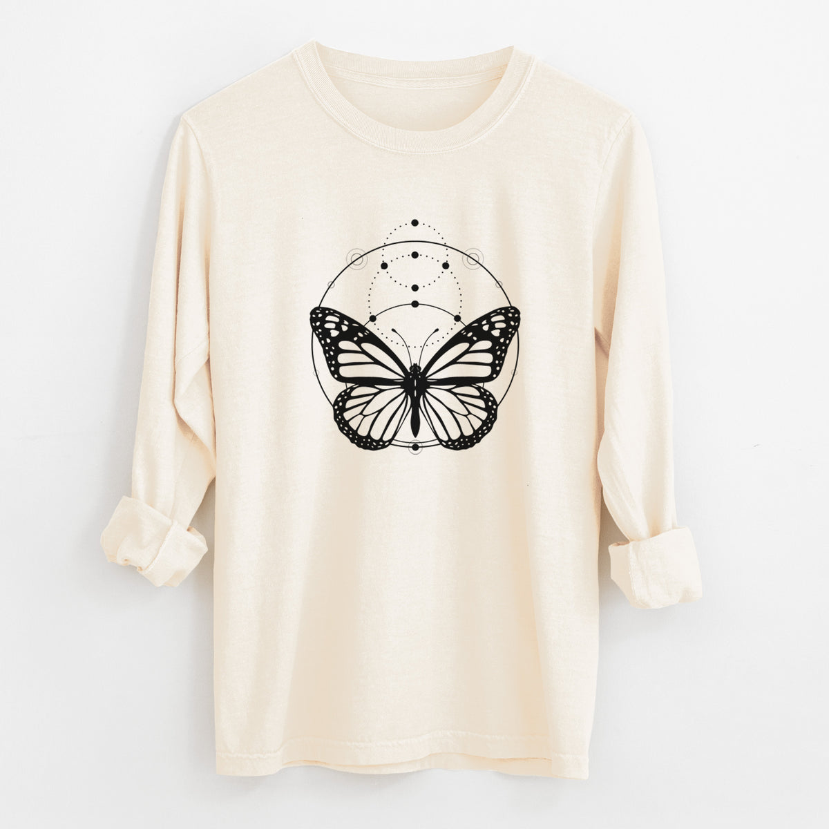 Ivory Comfort Colors long sleeve shirt laid flat with the cuffs rolled, printed with a black ink monarch butterfly inside a circle, beneath a line of moon phases.