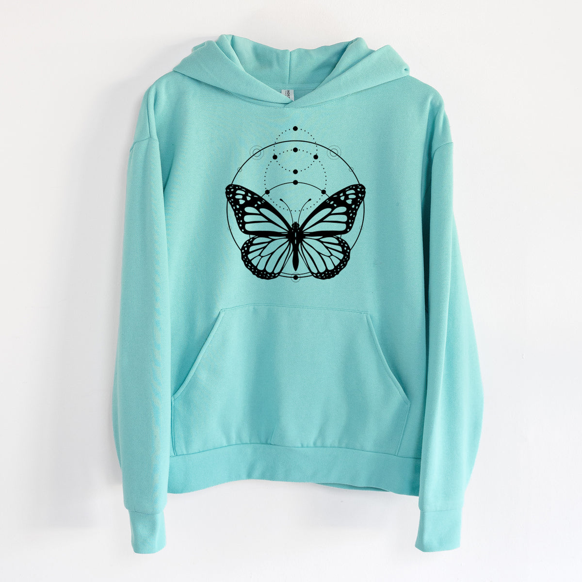 Monarch Symmetry - Statement Midweight Hoodie in Seafoam, hanging on a white wall, with a front kangaroo pocket and no drawcords.