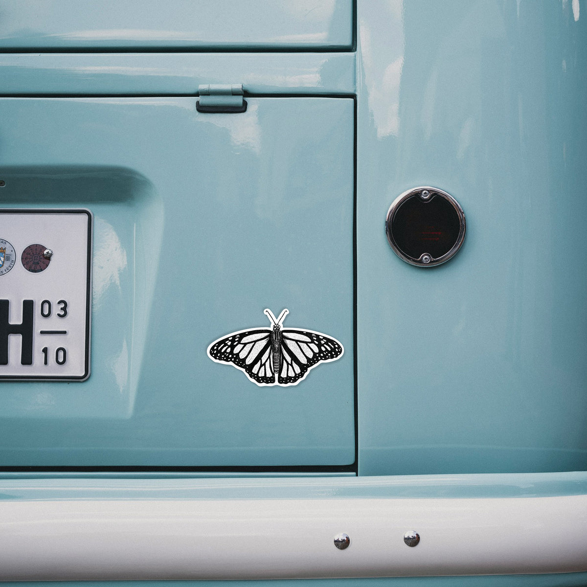 4 inch vinyl decal of a detailed black ink illustration of a monarch butterfly with its wings spread on the back of a van.