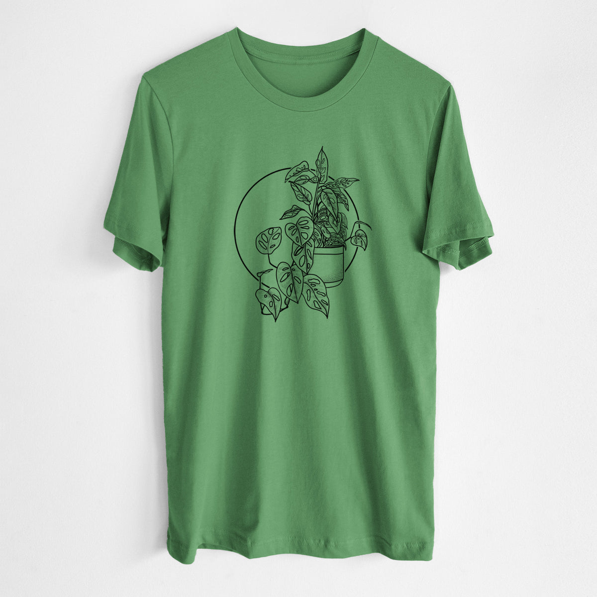 Leaf green lightweight cotton t-shirt laid flat, printed with a black ink illustration of a potted Monsteradansonii plant with trailing vines in front of a circle.