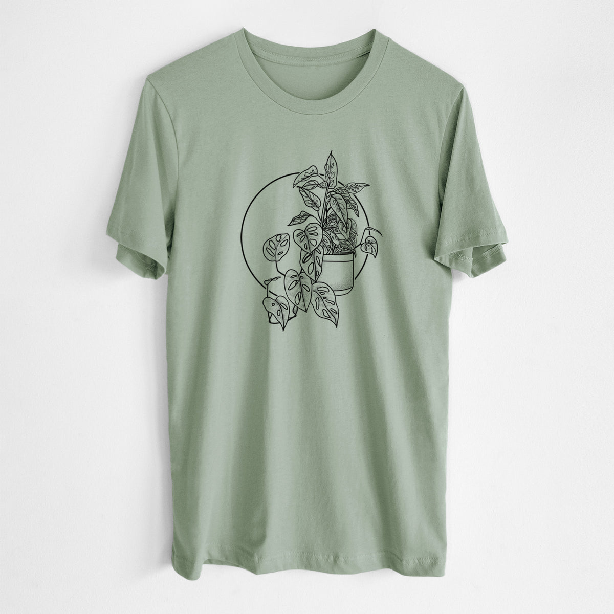 Sage green lightweight cotton t-shirt laid flat, printed with a black ink illustration of a potted Monsteradansonii plant with trailing vines in front of a circle.