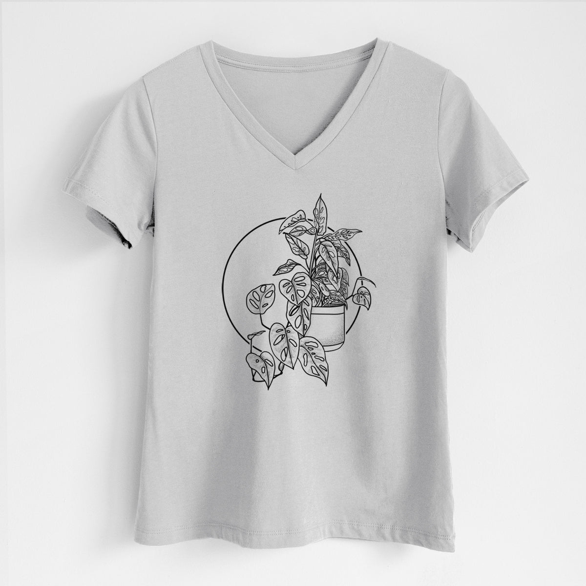 Lunar grey women's relaxed fit cotton V-neck t-shirt laid flat, printed with a black ink illustration of a potted Monsteradansonii plant with trailing vines in front of a circle.
