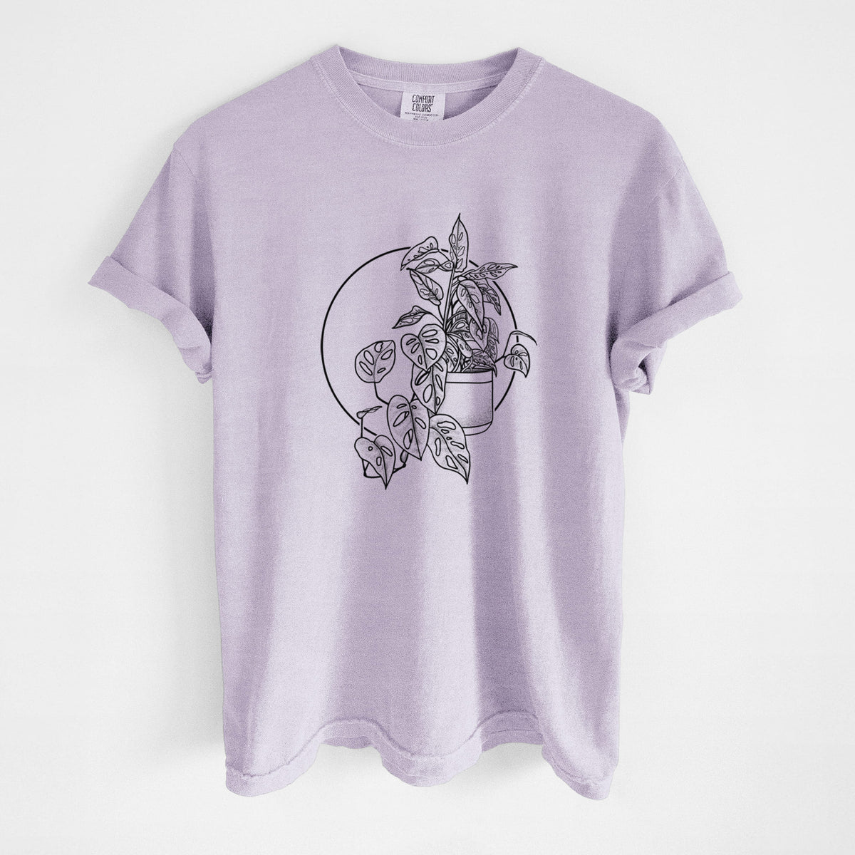 Orchid purple Comfort Colors t-shirt laid flat, printed with a black ink illustration of a potted Monsteradansonii plant with trailing vines in front of a circle.