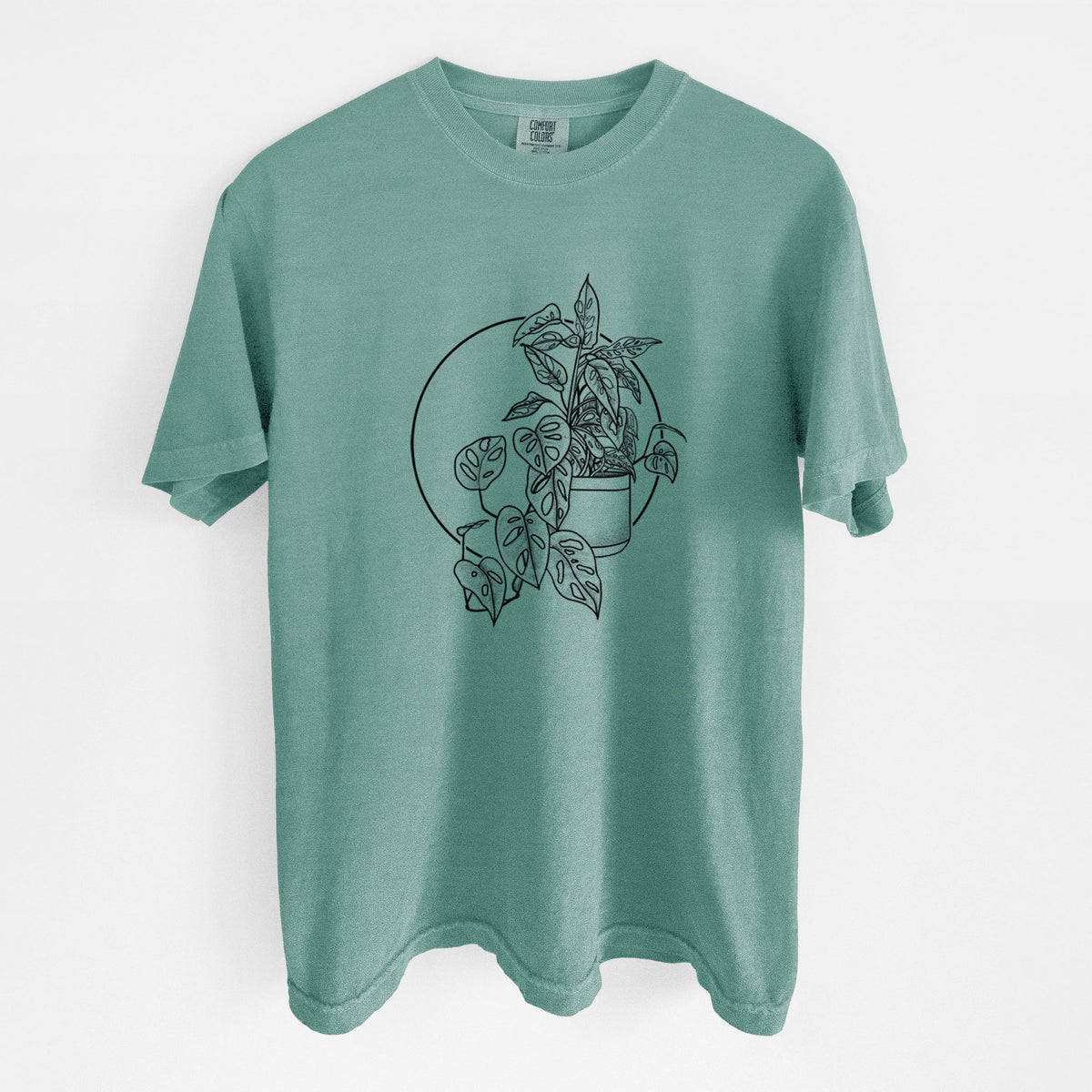 Reef green Comfort Colors t-shirt laid flat, printed with a black ink illustration of a potted Monsteradansonii plant with trailing vines in front of a circle.