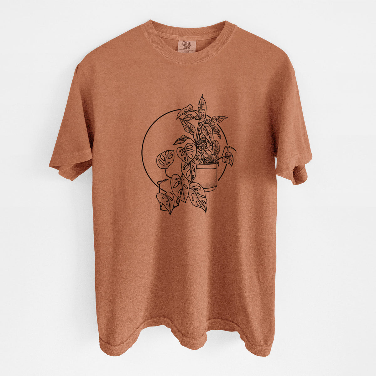 Yam burnt orange Comfort Colors t-shirt laid flat, printed with a black ink illustration of a potted Monsteradansonii plant with trailing vines in front of a circle.