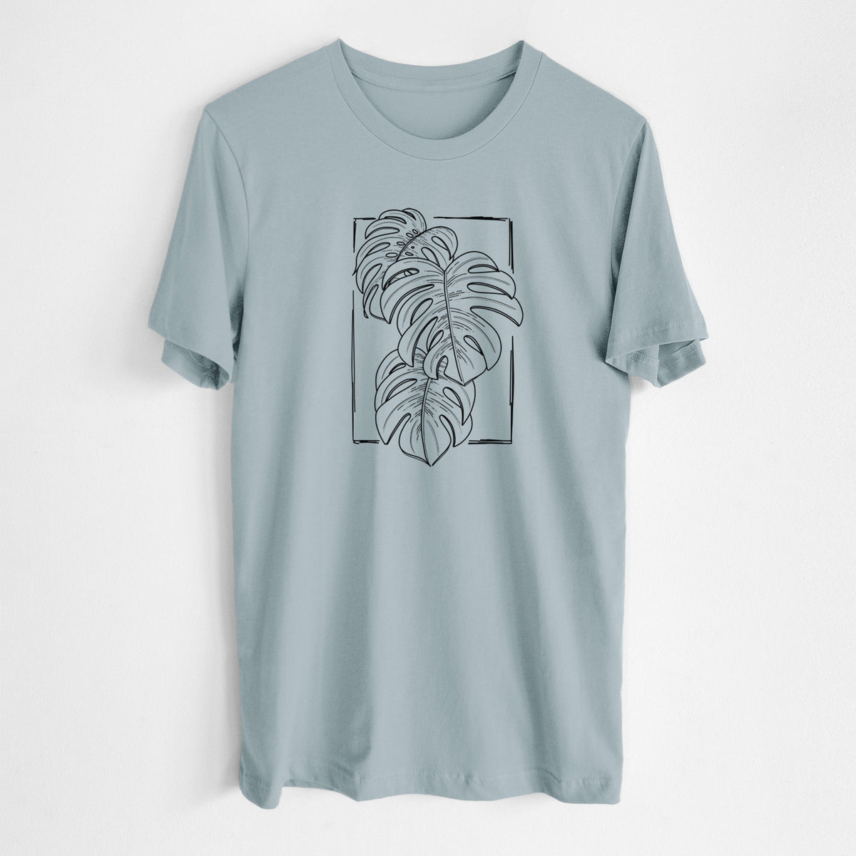 Vintage denim lightweight cotton t-shirt laid flat, printed with a black ink line drawing of Monstera deliciosa leaves inside a rectangle outline.