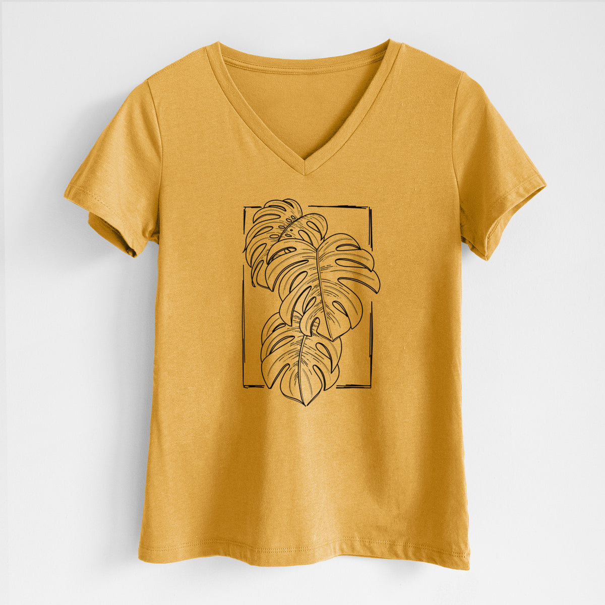 Honeycomb yellow women's relaxed fit cotton V-neck t-shirt laid flat, printed with a black ink line drawing of Monstera deliciosa leaves inside a rectangle outline.