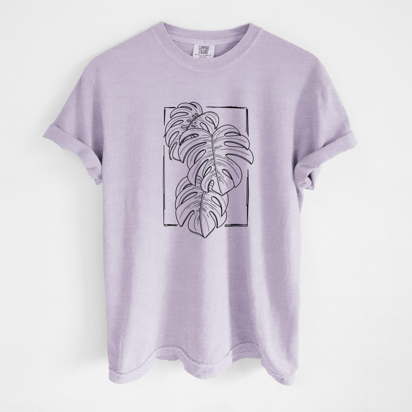 Blue jean Comfort Colors t-shirt laid flat, printed with a black ink line drawing of Monstera deliciosa leaves inside a rectangle outline.