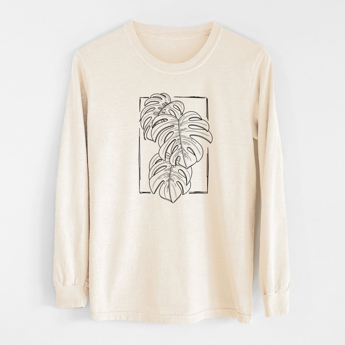 Ivory Comfort Colors long sleeve shirt laid flat, printed with a black ink line drawing of Monstera deliciosa leaves inside a rectangle outline.