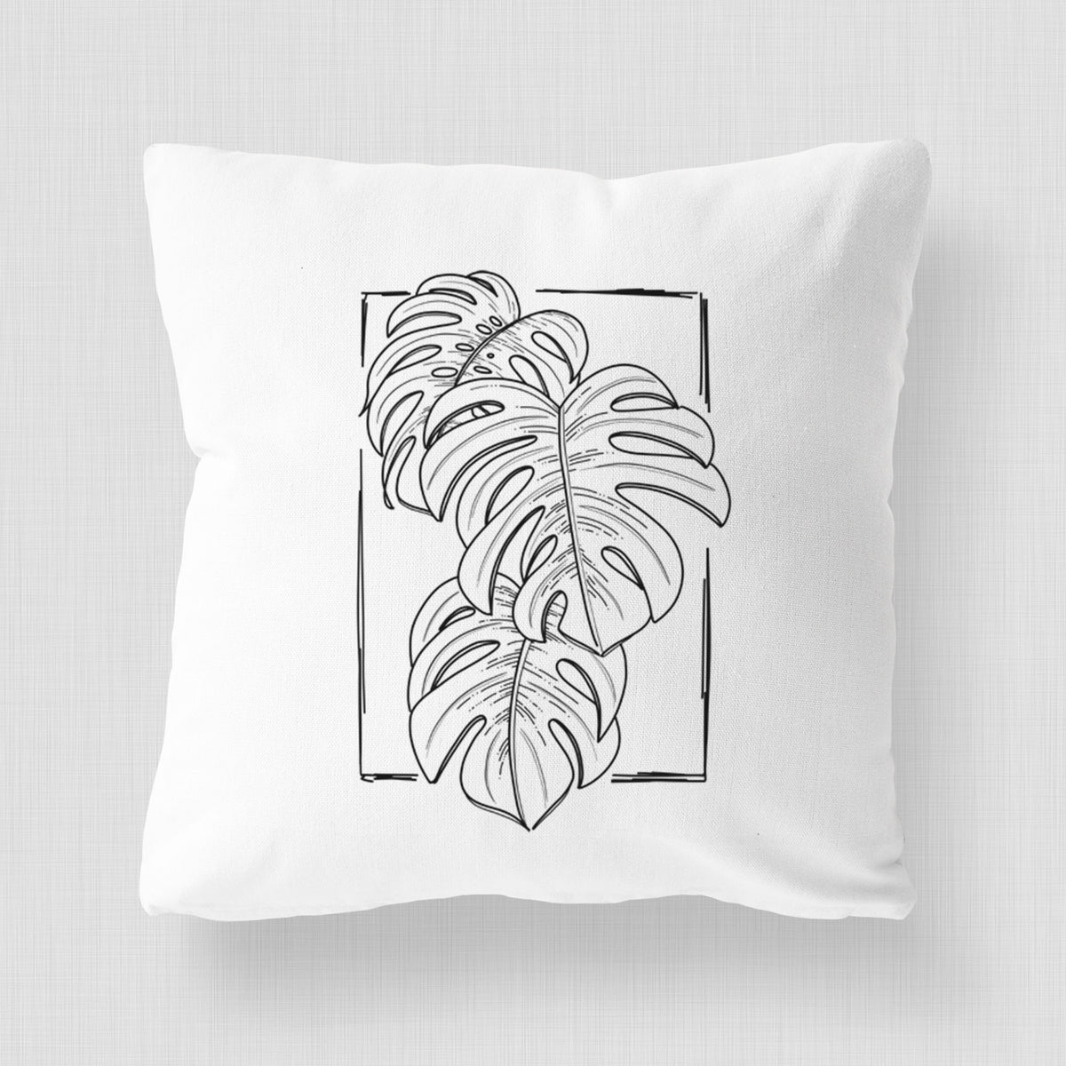 White pillow cover printed with a black ink line drawing of Monstera deliciosa leaves inside a rectangle outline.