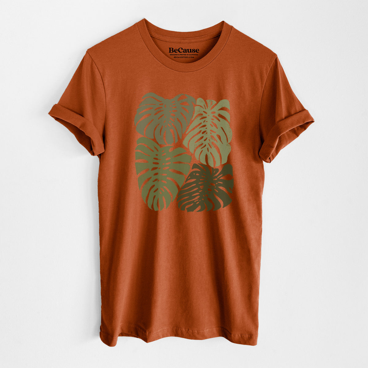 Autumn lightweight cotton t-shirt laid flat, printed with a full-color illustration of large green Monstera leaves filling a square.