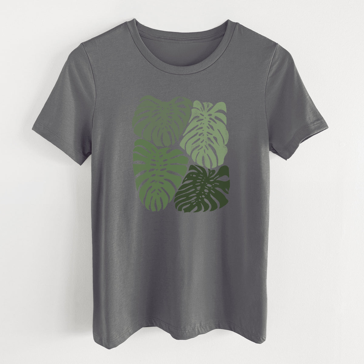 Asphalt women's relaxed fit cotton t-shirt laid flat, printed with a full-color illustration of large green Monstera leaves filling a square.