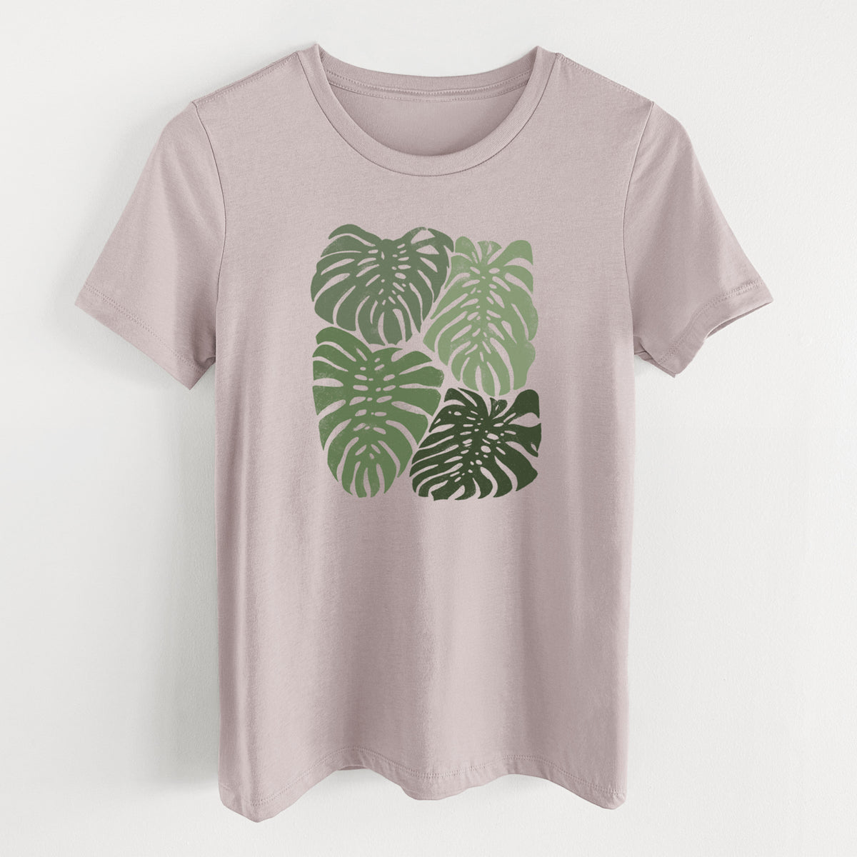 Pink gravel women's relaxed fit cotton t-shirt laid flat, printed with a full-color illustration of large green Monstera leaves filling a square.