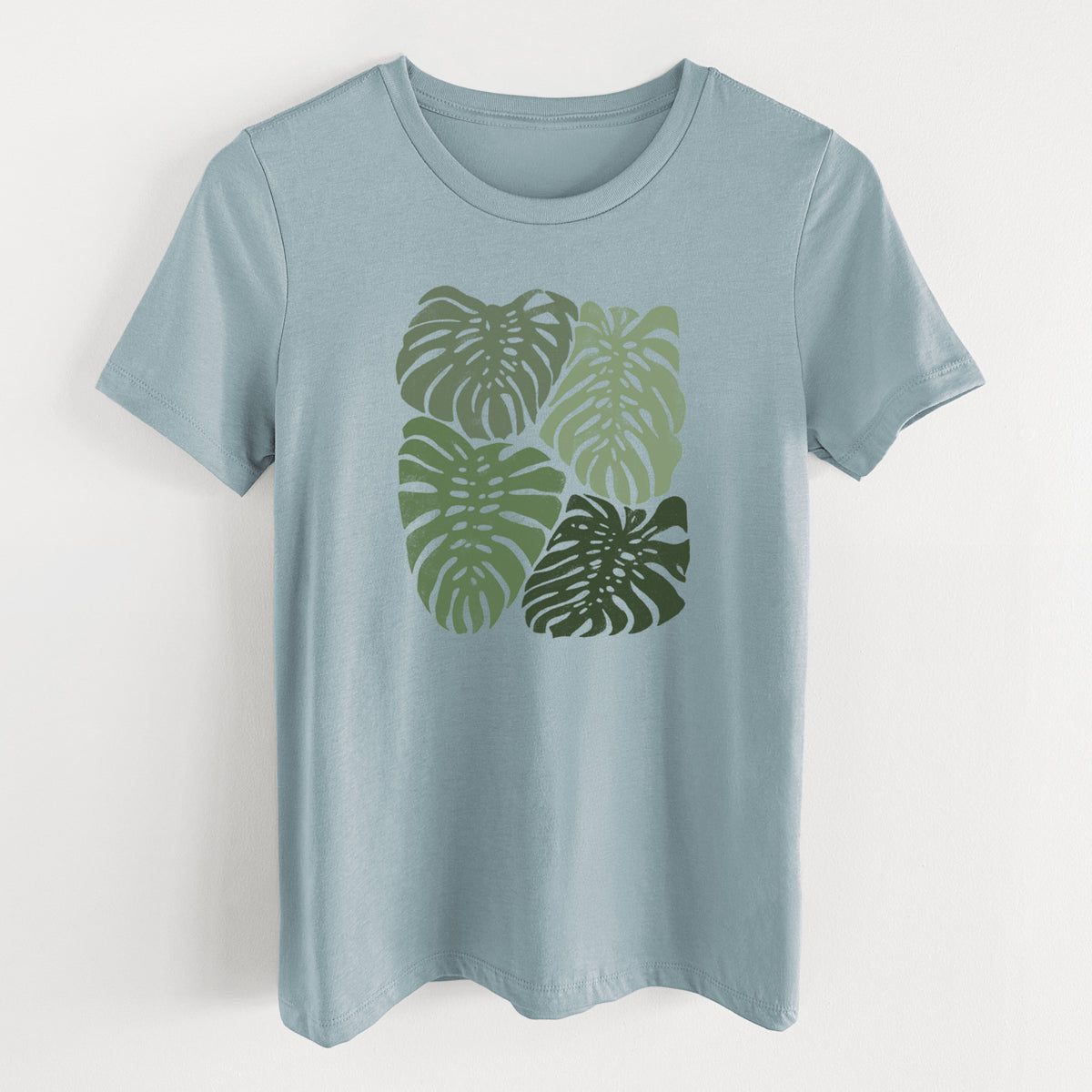 Vintage denim women's relaxed fit cotton t-shirt laid flat, printed with a full-color illustration of large green Monstera leaves filling a square.