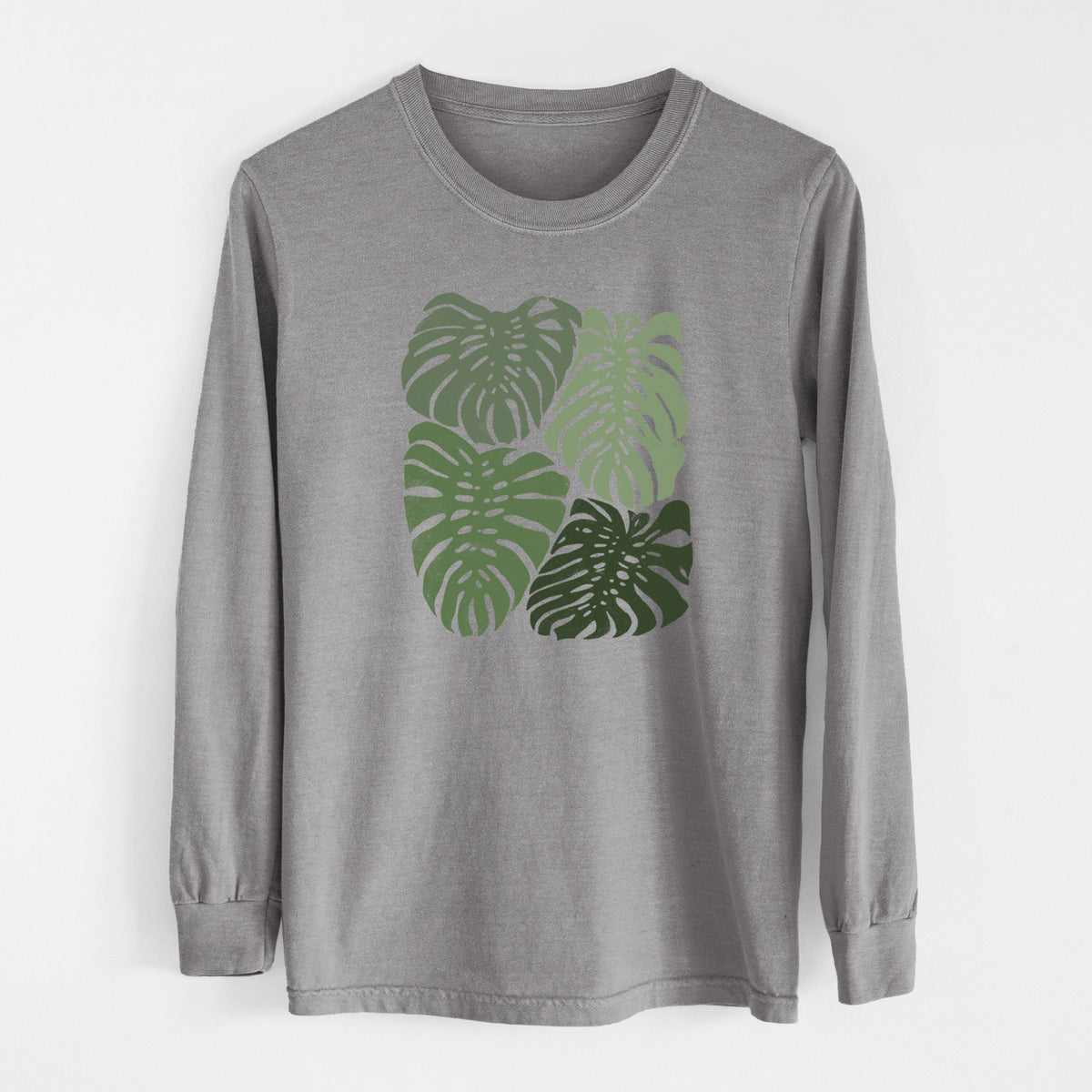 Grey Comfort Colors long sleeve shirt laid flat, printed with a full-color illustration of large green Monstera leaves filling a square.