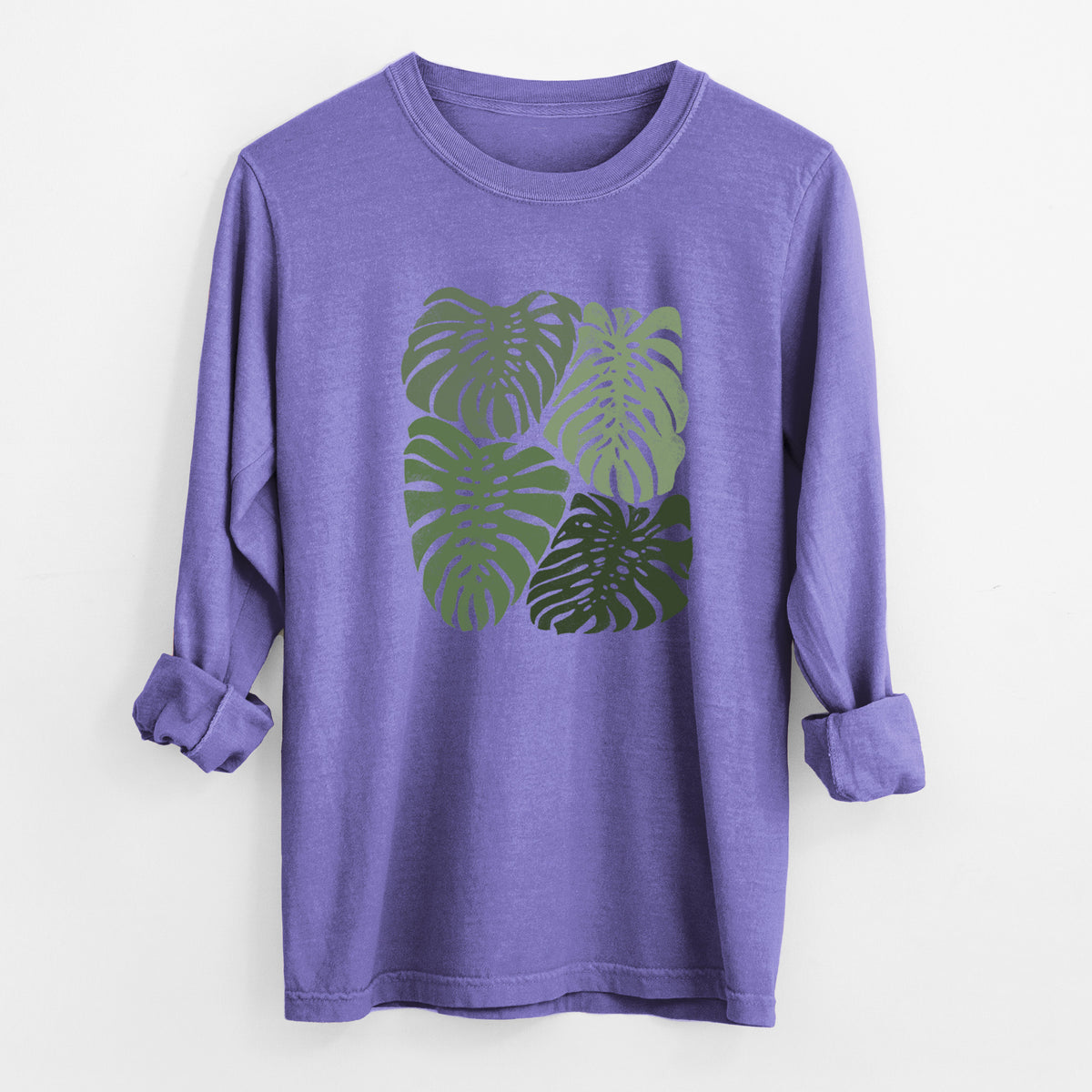 Violet purple Comfort Colors long sleeve shirt laid flat with the cuffs rolled, printed with a full-color illustration of large green Monstera leaves filling a square.