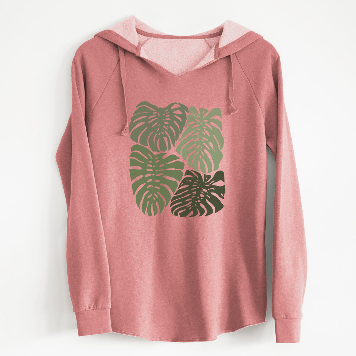 Dusty rose women's Cali Wave hooded sweatshirt laid flat, printed with a full-color illustration of large green Monstera leaves filling a square.