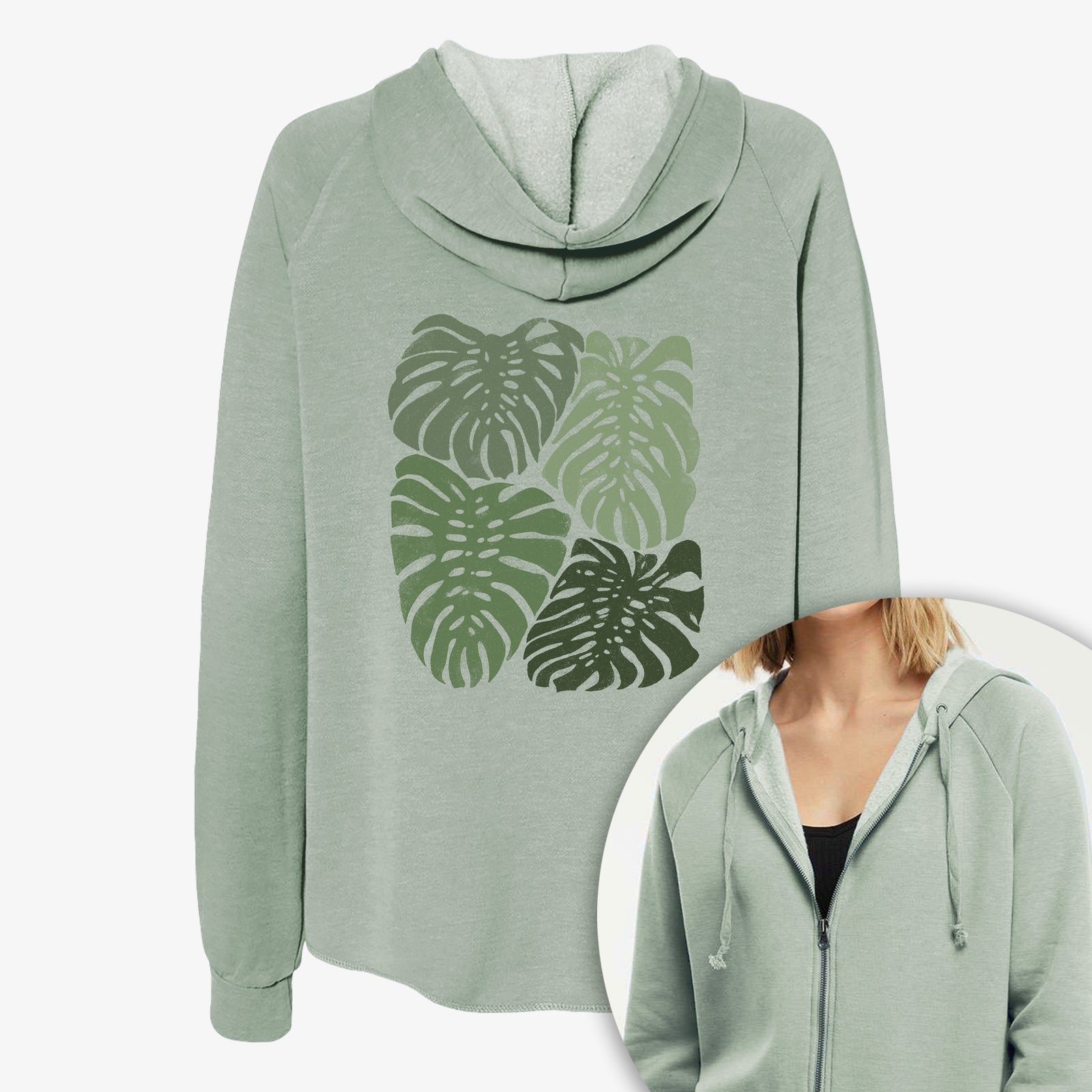 Women's Cali Wave zip-up sweatshirt printed with a full-color illustration of large green Monstera leaves filling a square, with a close-up of the zipper.