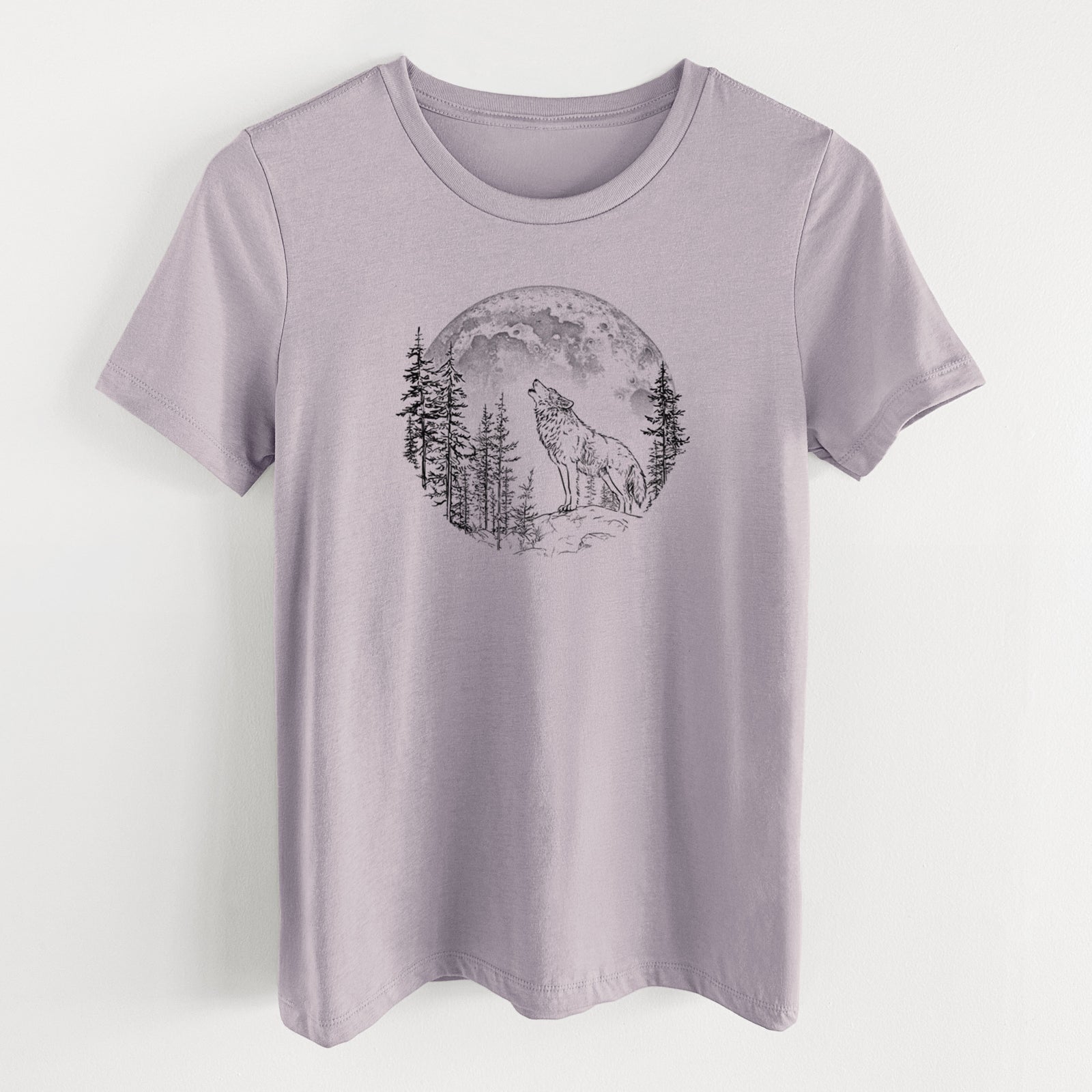 Light violet women's relaxed fit cotton t-shirt laid flat, printed with a black ink wolf howling in front of a full moon, surrounded by pine trees.