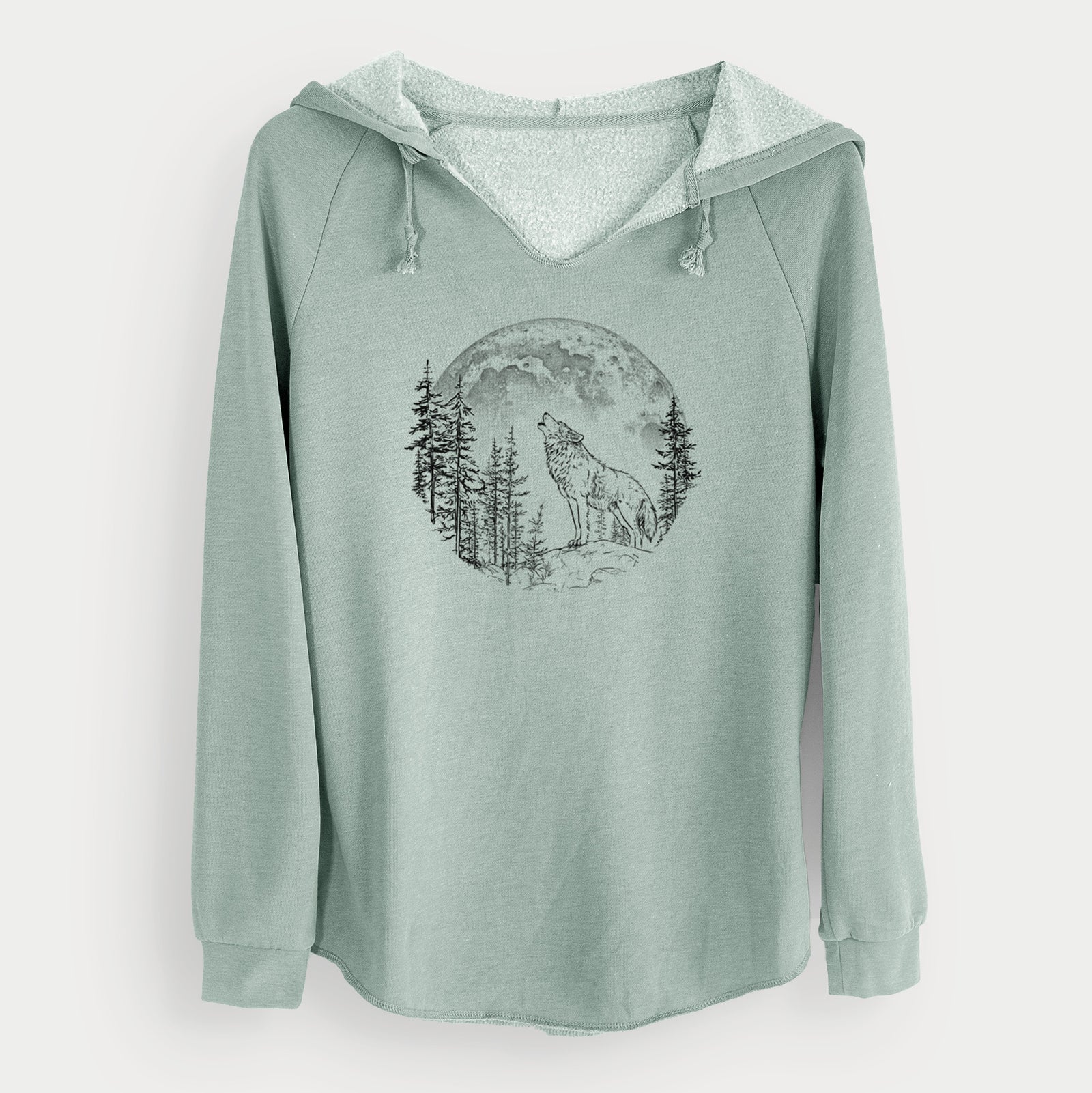 Sage green women's Cali Wave hooded sweatshirt laid flat, printed with a black ink wolf howling in front of a full moon, surrounded by pine trees.