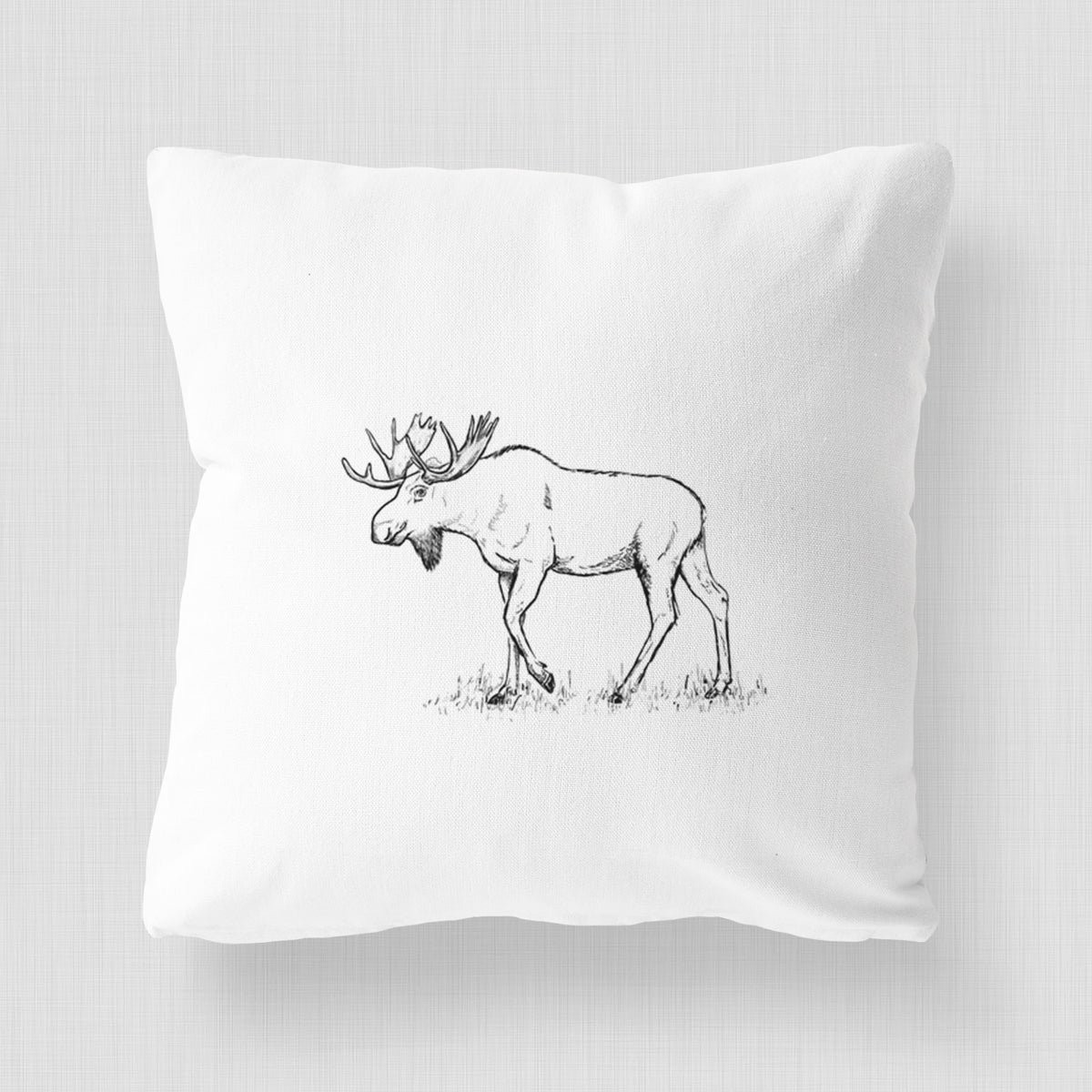 White pillow cover printed with a black ink illustration of a bull moose with broad antlers walking.