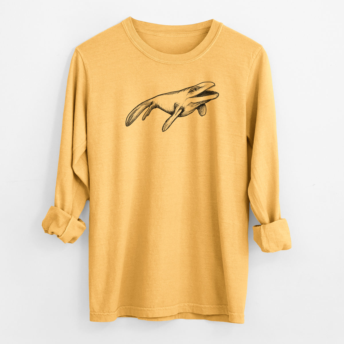 Golden wheat yellow Comfort Colors long sleeve shirt laid flat with the cuffs rolled, printed with a black ink illustration of a Mosasaur swimming.