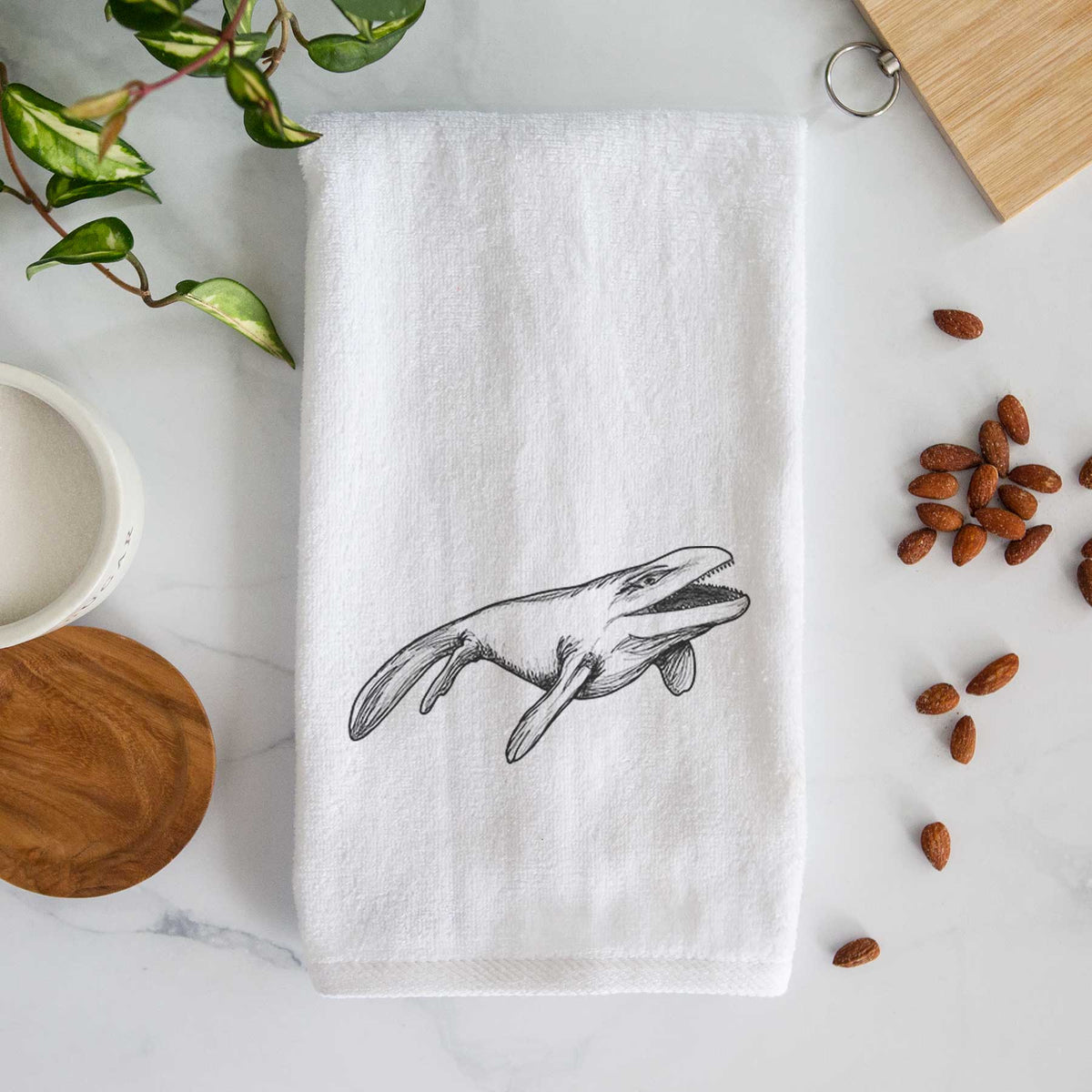 White hand towel printed with a black ink illustration of a Mosasaur swimming.