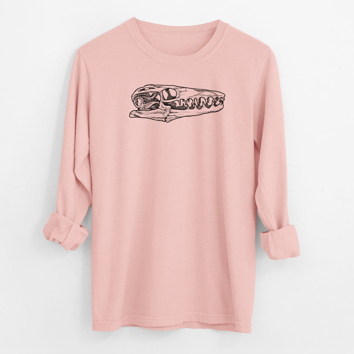 Peachy Comfort Colors long sleeve shirt laid flat with the cuffs rolled, printed with a detailed black ink illustration of a Mosasaur skull.